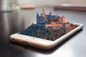 A phone with a castle coming out of the screen in 3D effect