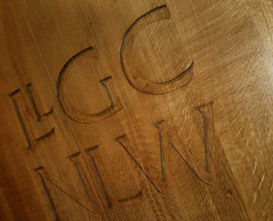 Carving on the spotlit podium, inside the Drwm auditorium