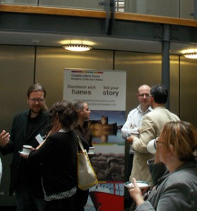 Delegates converse in front of a banner for the People's Collection Wales