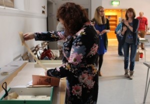 Woman looking at item from box-file